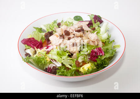 Salade de poulet aux tomates et au raisin blanc dans un bol. Plus isolé sur fond blanc Banque D'Images