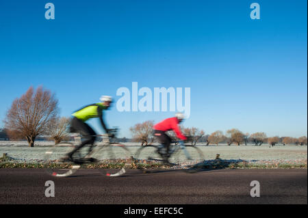 Deux courses cyclistes l'un contre l'autre lors d'une froide et très tièdes mais journée ensoleillée dans un parc de Londres Banque D'Images