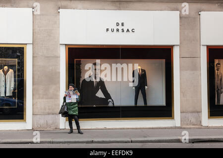 Un touriste à la recherche d'une carte à l'extérieur d'un costume de Fursac men's store, Sea, France Banque D'Images