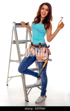 Une femme portant une ceinture pleine d'outil de bricolage une variété d'outils utiles sur un fond blanc. Banque D'Images