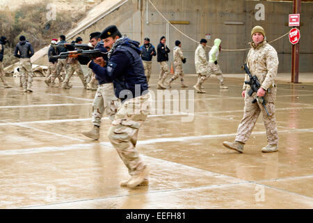 US Marine Le major Christopher Ross, un conseiller militaire avec le Groupe de travail air-sol marins, soldats de l'armée iraquienne warches manœuvre pratique techniques pendant la formation à Al Asad Air Base 15 janvier 2015, dans l'Iraq Heet,. L'armée des Etats-Unis est d'aider à développer le programme de formation pour les bataillons de l'armée irakienne dans un effort pour repousser l'État islamique. Banque D'Images