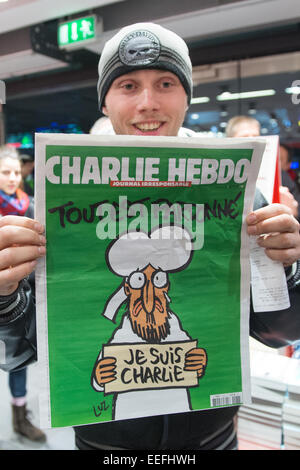 Berlin, Allemagne. 17 Jan, 2015. Kenny Rebenstock détient un exemplaire de la revue satirique 'Charlie Hebdo' dans la gare centrale de Berlin, Allemagne, 17 janvier 2015. Il avait attendu en face de la librairie depuis minuit, pour obtenir l'un des deux seuls exemplaires à 5 heures du matin. PHOTO : MAURIZIO GAMBARINI/dpa/Alamy Live News Banque D'Images