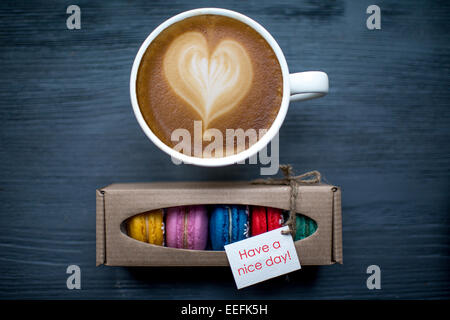 Tasse de café avec biscuits et macarons en forme de coeur sur la table en bois foncé Banque D'Images