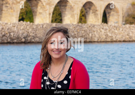 La tête et les épaules de plein air portrait de jeune adulte ou adolescent female smiling with stone arch bridge de Minneapolis en arrière-plan Banque D'Images