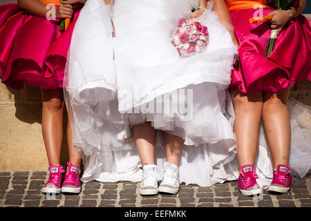 Mariée et ses demoiselles d'honneur dans leurs formateurs de mariage Banque D'Images