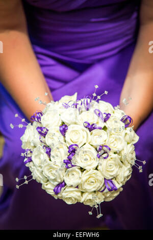 Demoiselle d'un mauve en tenant un bouquet de mariage Banque D'Images