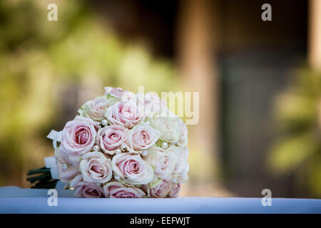 Bouquet de mariée rose rose placé sur un tableau blanc vêtu Banque D'Images
