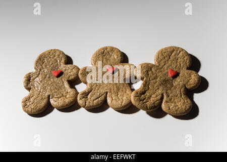 Trois Vacances de Noël Gingerbreadman Cookies avec bonbons coeur rouge Banque D'Images