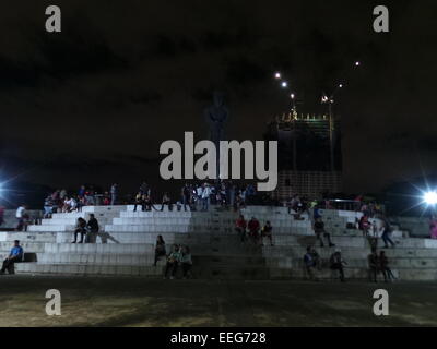 Les enfants jouent au monument des Héros philippin Lapu-lapu, tandis que leurs familles ont campé à l'extérieur de Quirino Grandstand. En dépit de Manille connaît des températures froides pour une moyenne de 21 à 25 degrés Celsius, des milliers de fidèles catholiques ont campé à l'extérieur des portes de Quirino Grandstand à Manille pour assister le Pape François' messe le dimanche après-midi, le 18 janvier 2015. Les gens apportent leur propre nourriture, Tente et matelas et sieste sur les terrains du parc en attendant l'ouverture des portes à 6 heures du matin. © Sherbien Dacalanio/Pacific Press/Alamy Live News Banque D'Images