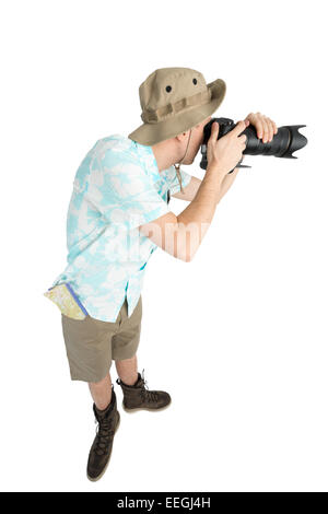 L'homme ridicule en maillot bleu, short marron et hat holding big photo reflex numérique et le tir. Traveler se concentrer et faire pi Banque D'Images