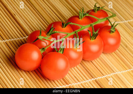 Une botte de 9 tomates rouges sur la vigne. Banque D'Images