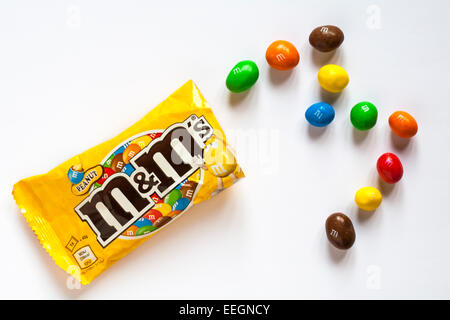 Sachet de M&M's peanut avec matières disposés en lettre M isolé sur fond blanc Banque D'Images