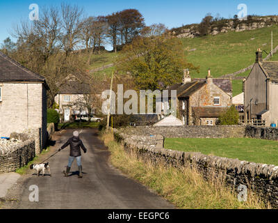 UK, Derbyshire, Tideswell to, Litton village, dog Walker sur le bord de la route en dessous de Litton Banque D'Images