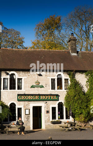 UK, Derbyshire, Tideswell to, fumeur à l'extérieur de l'hôtel George public house en automne Banque D'Images