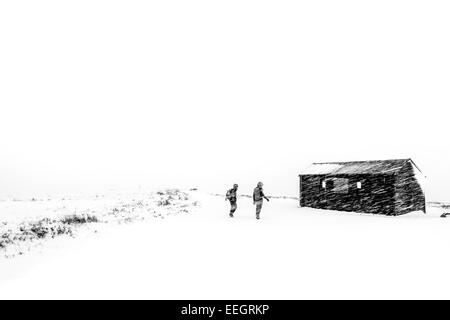 Les marcheurs dans une tempête de neige sur une balade d'hiver, campagne du Yorkshire , Royaume-Uni Banque D'Images