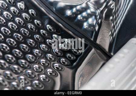 Plan Macro sur l'intérieur d'un tambour de machine à laver montrant les trous de vidange et d'un déflecteur Banque D'Images