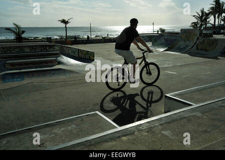 Durban, le KwaZulu-Natal, Afrique du Sud, seul adulte man riding mountain bike dans un skate park at beachfront Banque D'Images