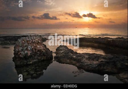 Coucher de soleil sur la mer et côte rocheuse avec d'anciennes ruines à Mahdia, Tunisie Banque D'Images