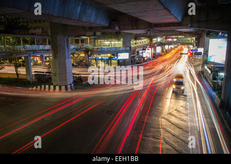 Sentiers de véhicules légers à une rue sous un pont en béton, la nuit à Bangkok, Thaïlande. Banque D'Images