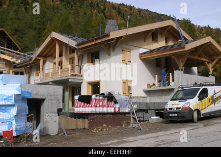 Site de la construction résidentielle dans les Alpes françaises. Heureux en béton et en bois de la propriété de vacances chalet de construction. Banque D'Images