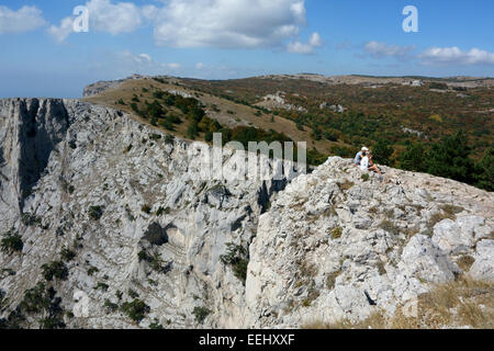 Un couple assis sur le bord de la falaise, Mont Ai-Petri, Crimée, Russie Banque D'Images