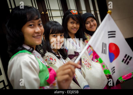 Les étudiants indonésiens portant la robe traditionnelle coréenne « hanbok », alors qu'ils détiennent des drapeaux sud-coréens au Centre culturel coréen de Jakarta, en Indonésie. Banque D'Images