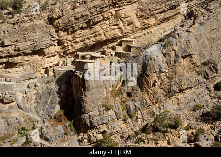 Maisons traditionnelles en pierre dans un petit hameau près de falaise dans le Djebel Akhdar Sroot montagnes du Sultanat d'Oman. Banque D'Images