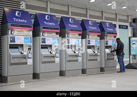 Un passager utilise l'une des 5 machines de ticket à la Station London Bridge Banque D'Images