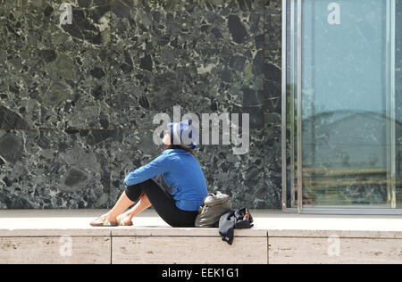 Femme assise à l'extérieur de pavillon de Barcelone conçu par l'architecte allemand Mies van der Rohe, Montjuïc, Barcelone Banque D'Images