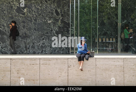 Femme assise à l'extérieur de pavillon de Barcelone conçu par l'architecte allemand Mies van der Rohe, Montjuïc, Barcelone Banque D'Images