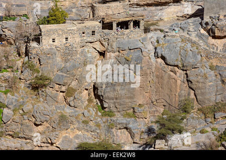 Les hommes omanais dans leur majlis, ou d'un lieu de rencontre, au milieu des maisons traditionnelles en pierre dans un petit hameau de falaise dans le Djebel Akhdar, Oman. Banque D'Images