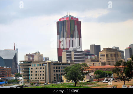 Un gratte-ciel couvert Coca Cola dans le quartier central des affaires de Johannesburg vue de loin. Banque D'Images