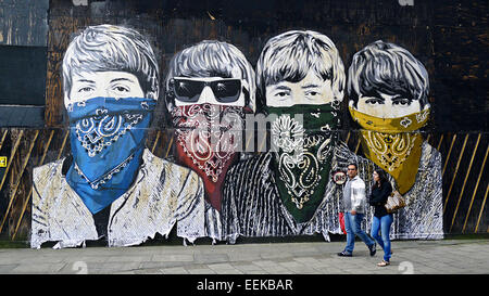 Beatles, portant bandana couleur peinture sur mur,mouchoirs, graffiti man and woman walking passé en premier plan Banque D'Images