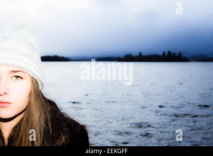 Traitées portrait of young woman standing by lake Banque D'Images