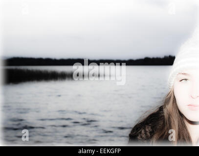 Traitées portrait of young woman standing by lake Banque D'Images