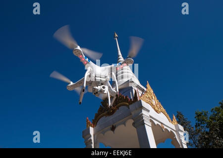 Un appareil radio controlled quadcopter drone survolant un sanctuaire bouddhiste à Phu Ruea Parc National dans le Nord de la province de Loei en Thaïlande Banque D'Images