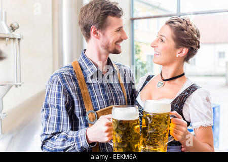 Brasseur et woman toasting in beer brewery Banque D'Images