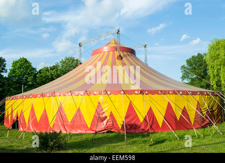 Tente de cirque en rouge et jaune pour les représentations installées dans un parc Banque D'Images