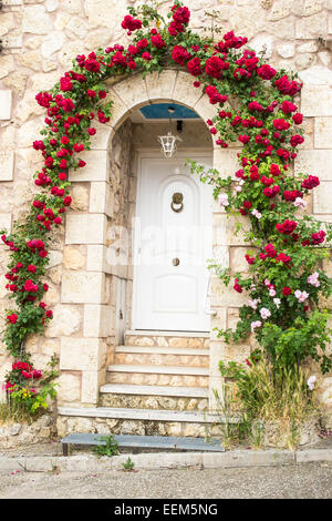 House entrée décorée d'une arcade de roses rouges et roses Banque D'Images