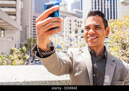 Hispanic businessman en tenant selfies téléphone cellulaire Banque D'Images