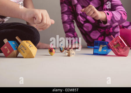 Deux jeunes filles jouant avec des dreidels pour célébrer la fête des Lumières Banque D'Images