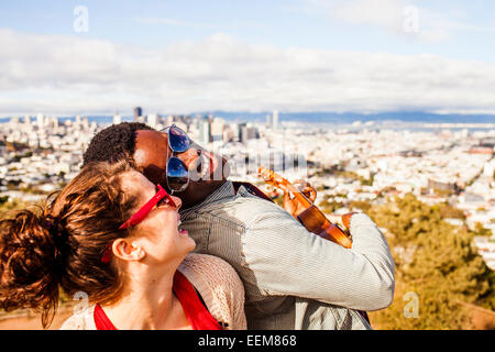 Couple playing ukulele près de scenic view of cityscape Banque D'Images