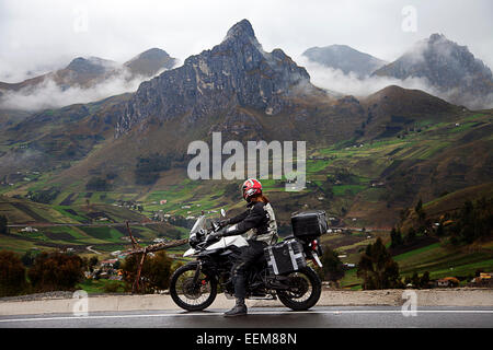 Homme sur un moto qui attend sur le côté d'une route de montagne, Tigua, Pujilí, Cotopaxi, Equateur Banque D'Images