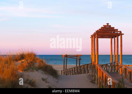 Passerelle en bois menant à la plage au lever du soleil, Cadix, Andalousie, Espagne Banque D'Images