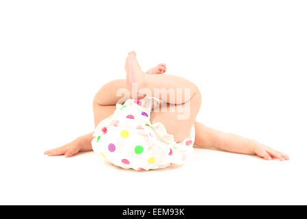 Bébé fille couché sur le sol dans un pantalon à couches pois Banque D'Images