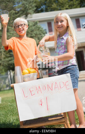 Des enfants de race blanche limonade vente dans la cour avant Banque D'Images