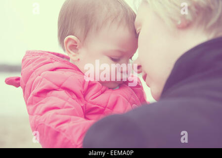 Portrait de Mère et bébé fille (6-11 mois) toucher leur front Banque D'Images