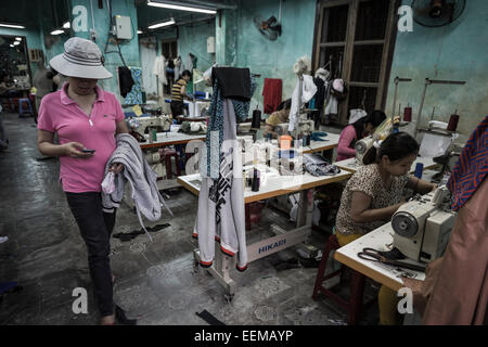 Plusieurs femmes travaillant dans une usine textile. L'un des moteurs de l'économie vietnamienne est la production du textile et de la chaussure. Banque D'Images