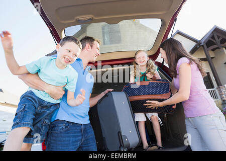 Caucasian family unpacking valises de la voiture Banque D'Images