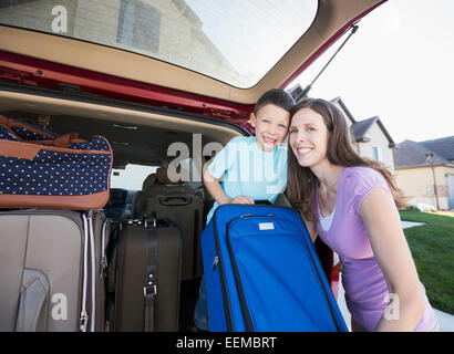 Caucasian mother and son smiling avec des valises dans... Banque D'Images